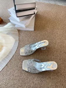 Dettaglio dei sabot in strass argento con punta quadrata e tacco largo trasparente