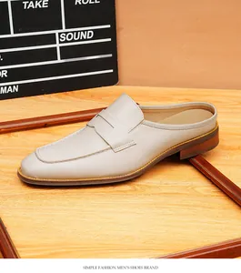Primer plano de mules para hombre de cuero beige con elegante punta y suela de madera