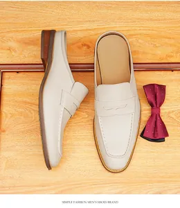 Detalle de elegantes mocasines destalonados de cuero blanco roto para hombre con banda