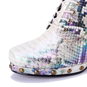 Macro detail of iridescent snake print boot featuring punk metal studs and white laces.