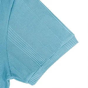 Primer plano detalle de la textura del tejido de punto azul en un polo de hombre.