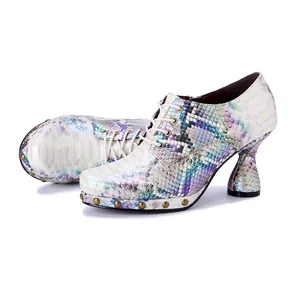 Detail view of iridescent snakeskin high heels with metallic punk studs and chunky heel.