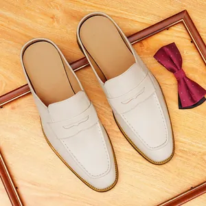 Elegantes mocasines destalonados de cuero beige para hombre con costura estilo mocasín.