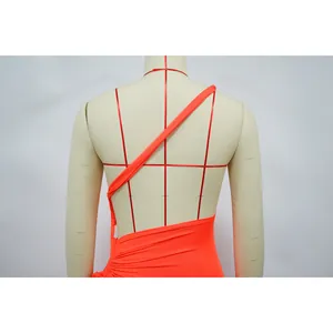 Gros plan sur les plis du dos et le tissu d'une robe orange vif à une épaule
