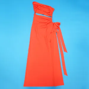 Détail de la robe maxi orange vif à une épaule avec fente latérale et nœud