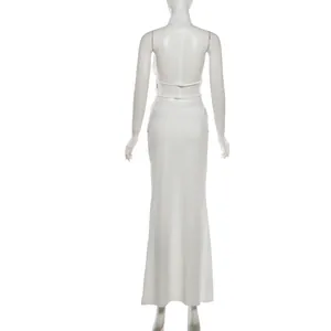 Detail view showing the backless design of white halter top and matching long skirt