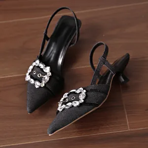 Nahaufnahme von blauen Denim-Pumps mit spitzer Zehenpartie und eleganter Strassschnalle