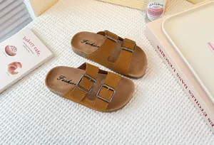 Primer plano de sandalias de gamuza marrón para niñas con diseño de doble hebilla