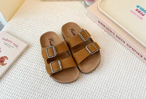 Detalle de sandalias marrones para niños en ante mate con hebillas metálicas dobles