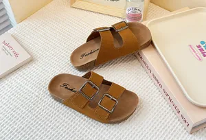 Primer plano de sandalias de gamuza marrón para niñas con correas de hebilla doble