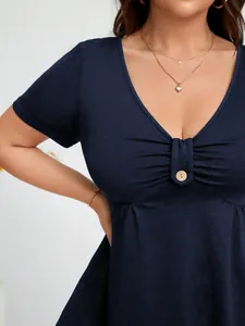 Dettaglio di un top blu scuro con scollo a V, busto arricciato e bottone decorativo