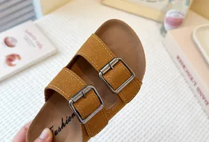 Detalle de cerca de sandalias de gamuza marrón para niñas con hebillas de metal