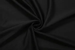 Close-up detail of soft black fabric texture with elegant drapes for a sexy skirt set