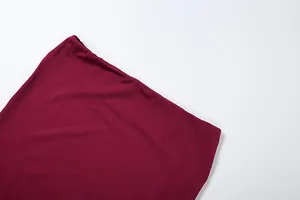 Macro view of burgundy stretch fabric detail showing high-quality stitching and texture.
