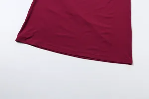 Detailed macro view showing the clean hemline and stitching of the burgundy skirt.