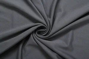 Macro view of grey knitted fabric texture showing soft drape and elastic weave