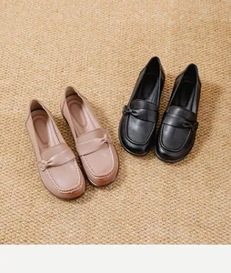 Comfortable women's slip-on loafers in black and beige displayed on a textured mat