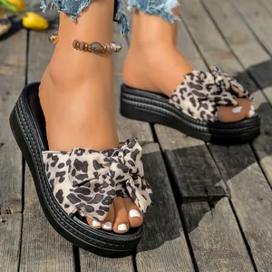 Primer plano de elegantes sandalias de plataforma con lazo de leopardo y diseño abierto.
