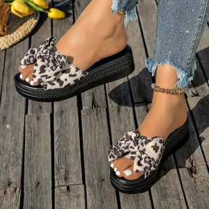 Primer plano de elegantes sandalias de plataforma con estampado de leopardo y lazo