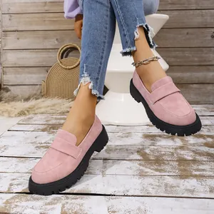 Detailed view of stylish pink suede loafers with chunky black platform soles worn by a model