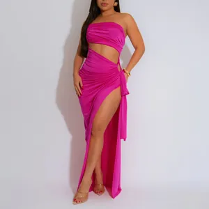 Vue détaillée d'une robe longue fuchsia bustier avec découpe à la taille et fente haute