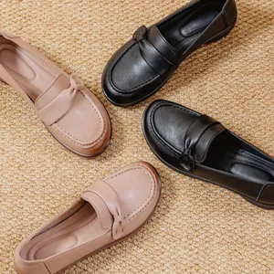 Comfortable women's slip-on loafers in black and beige displayed on a textured mat