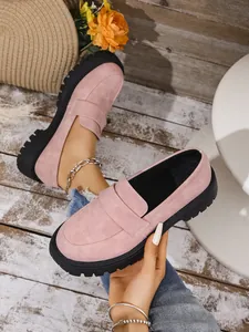 Detailed view of stylish pink suede slip-on loafers with chunky black platform sole