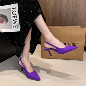 Elegant purple pointed toe slingback kitten heels worn by model in a chic setting