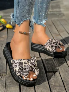 Zapatillas de plataforma con estampado de leopardo, lazo y suela de cuña negra texturizada
