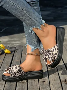 Primer plano de sandalias de plataforma para mujer con lazo de leopardo y suela negra