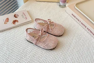 Close-up of pink lace mesh Mary Jane flats for girls featuring a delicate bow detail