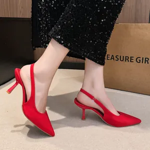 Close-up detail of elegant red pointed-toe slingback kitten heels in refined satin texture