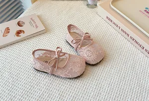 Close-up detail of pink lace mesh Mary Jane shoes with elegant bow decoration for girls