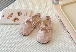 Close-up of pink lace mesh Mary Jane shoes with bow for girls, spring collection