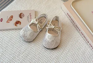 Detailed view of the breathable white lace floral embroidery on the children's Mary Jane shoes.