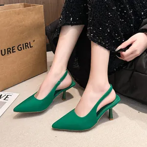 Detail view of emerald green pointed-toe slingback heels with fabric texture