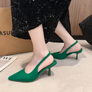 Elegant vibrant green pointed-toe slingback stiletto heels showcased on a model.