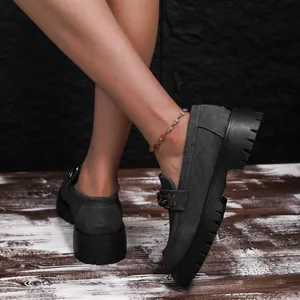 Κομψά γυναικεία loafers με πλατφόρμα και αλυσίδα σε ρουστίκ ξύλινο δάπεδο.