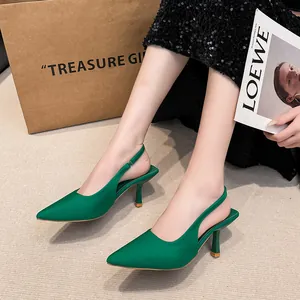 Detail view of emerald green pointed-toe slingback high heels with stiletto heels.