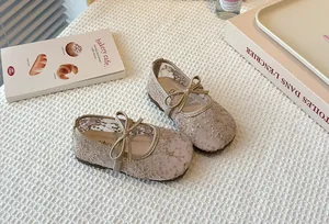 Close-up of elegant beige lace mesh Mary Jane shoes with butterfly bow for girls