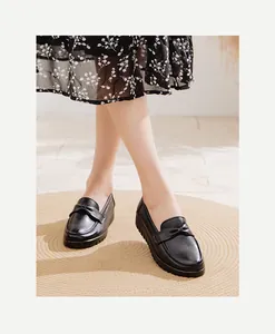 Détail rapproché de mocassins en cuir noir pour femmes avec semelle souple et nœud élégant