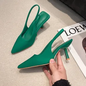 Emerald green slingback kitten heels with a pointed toe design and stiletto heels