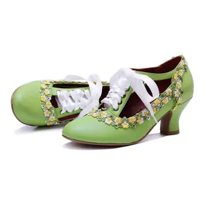 Close-up of green leather Mary Jane heels with yellow floral lace and white ribbons