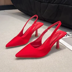 Macro view of elegant red pointed-toe slingback heels with a silky satin finish