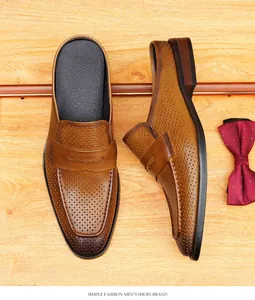 Mocasines tipo mule de cuero marrón perforado para hombre sobre fondo de madera clara