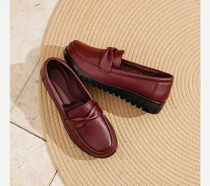 Vue de dessus de mocassins en cuir bordeaux confortables avec nœud sur un tapis