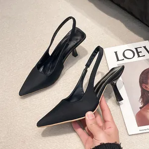 Detailed close-up of elegant black pointed toe slingback sandals with stiletto heels.