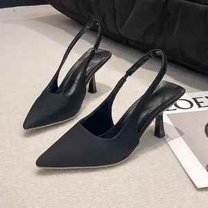 Detailed side view of black pointed-toe slingback sandals with slim high heels