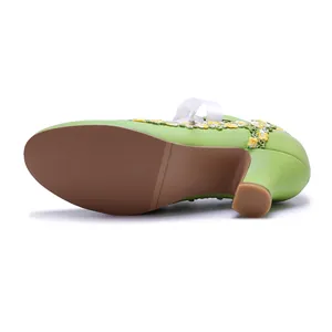 Detailed view showing the textured brown sole of vintage green lace Mary Jane heels