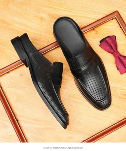 Vista detallada de los mules de negocios para hombres en cuero perforado negro.